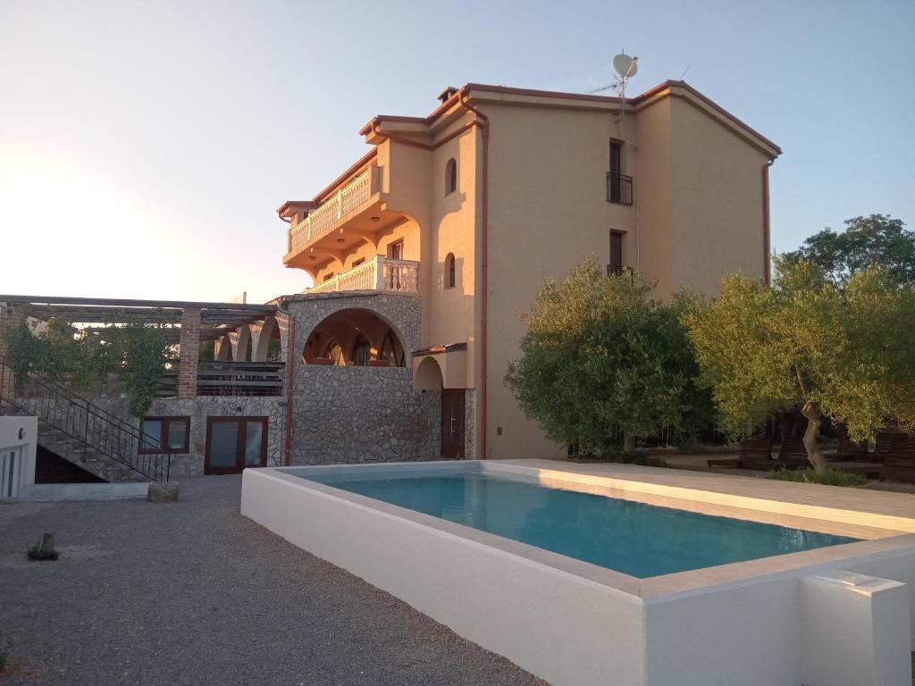 una casa con piscina delante de un edificio en Bed & Breakfast Tonivale, en Skrbčići