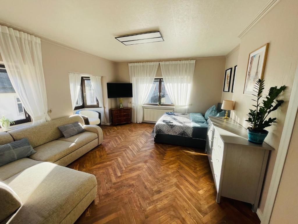 ein Wohnzimmer mit Couch und Bett und ein Zimmer mit in der Unterkunft Ferienwohnung-Oberstein im Zentrum in Idar-Oberstein