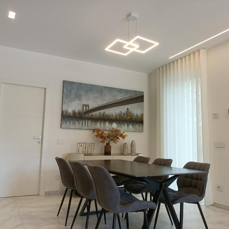 a dining room with a black table and chairs at Holiday Home Varese- Family & Group stay with private parking in Varese