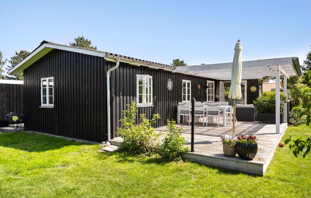 a black house with a wooden deck in the yard at Nice Home In Haderslev With Wifi in Haderslev