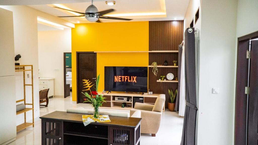 Una sala de estar con un sofá y un televisor. en Puri Anturan Lovina, en Lovina