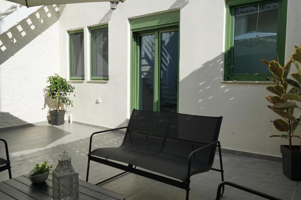 a black chair sitting on the porch of a house at Casa di Keti - Modern Home with Private Yard ,3 Min to the Beach in Chania