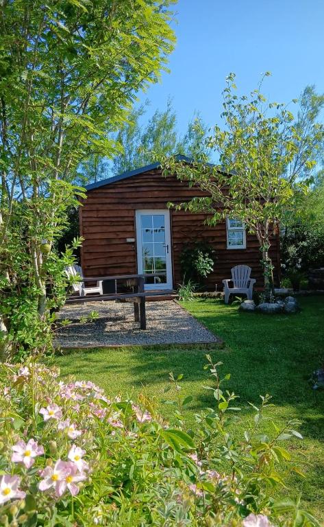 una cabaña de madera con un banco en el patio en Robins Rest, en Donegal