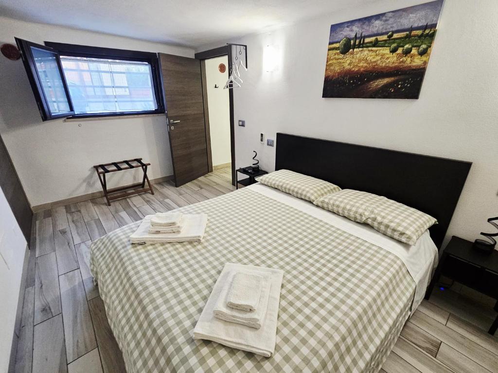 a bedroom with a large bed with a checkered blanket at Sweet Pisa Guesthouse in Pisa