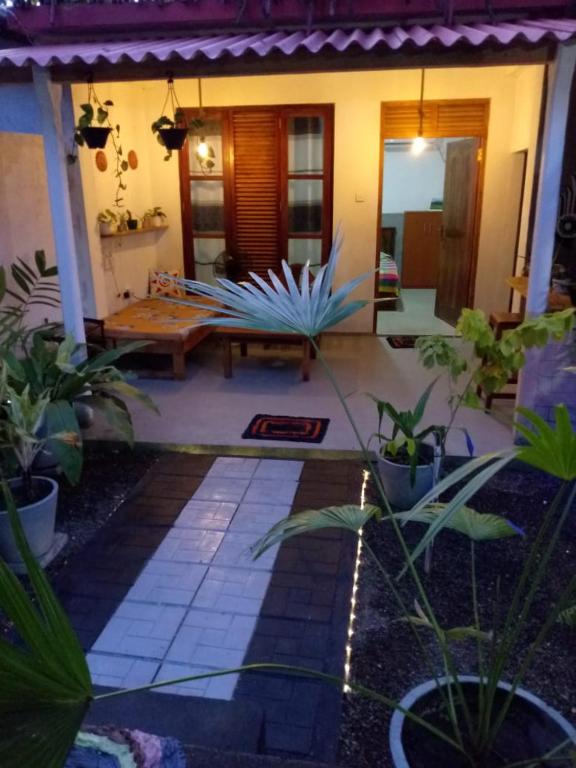 a house with a patio with plants in front of it at Yeli gray house in Weligama