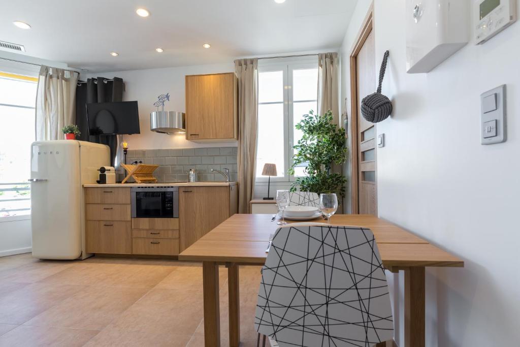 a kitchen with a wooden table and a refrigerator at Palais Saint Pierre in Cagnes-sur-Mer