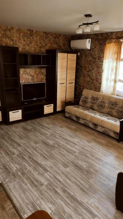 a living room with a couch and a television at Дарина in Chornomorsk