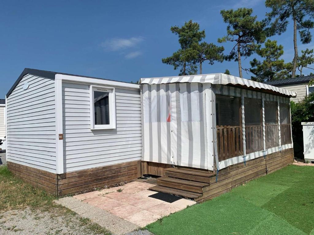 un petit hangar blanc au-dessus d'une cour dans l'établissement Le parc des roselieres 40 Saint Hilaire de Riez, à Saint-Hilaire-de-Riez