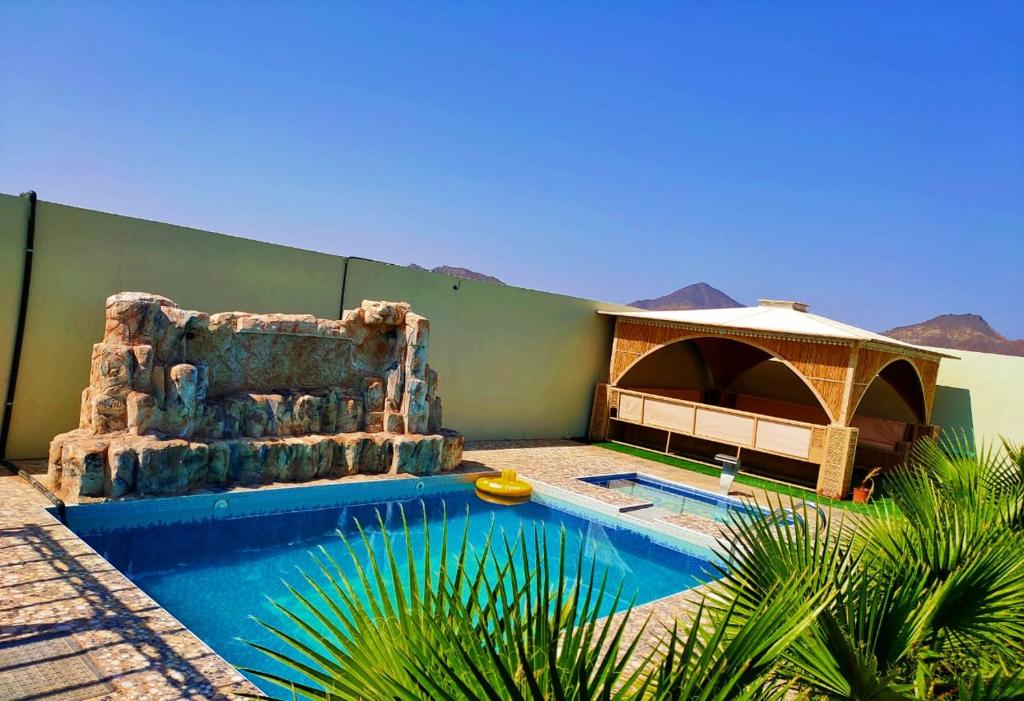 Ţaymissahにあるاستراحة الاصالة alasalahの椅子付きのプールが隣接しています。