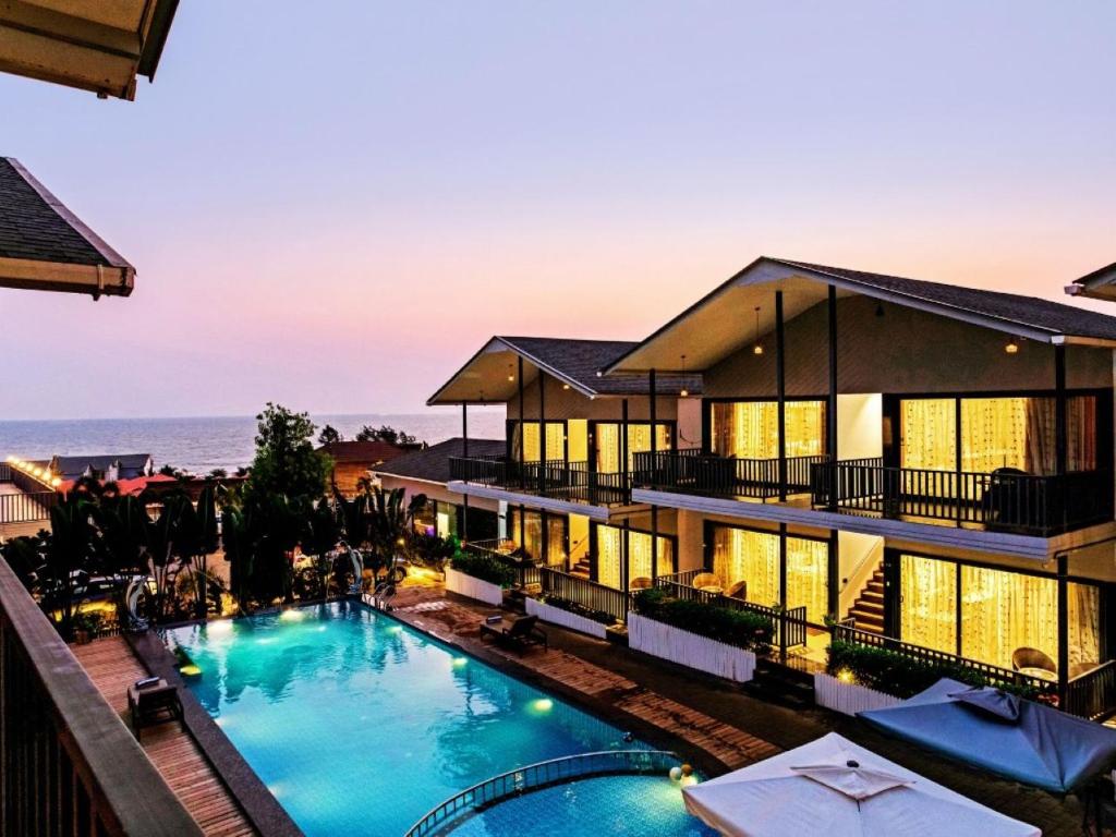 a large building with a swimming pool in front of it at Dallas Beach Resorts Ashvem Beach in Mandrem