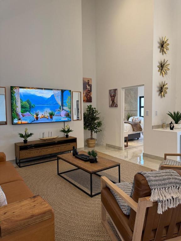a living room with a large flat screen tv on the wall at Hermanus Villa in Hermanus