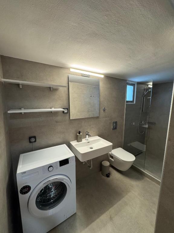 W łazience znajduje się pralka i umywalka. w obiekcie Remvi Suite in Chania w mieście Xamoudhokhórion