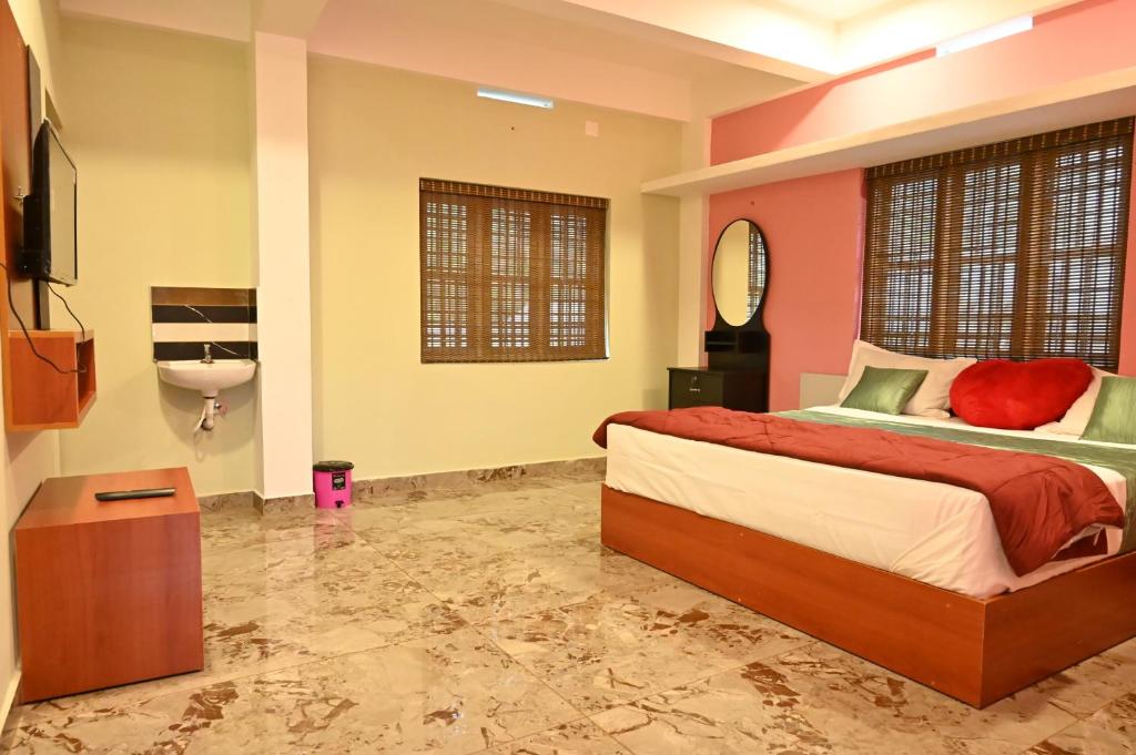 a bedroom with a bed and a bathroom with a sink at Brownstones Resort in Kanthalloor