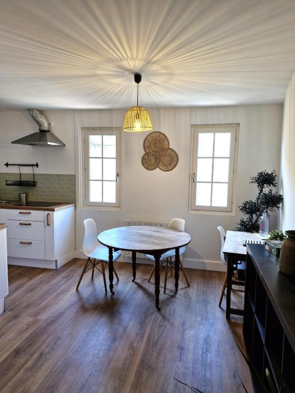 une cuisine avec une table et des chaises dans une pièce dans l'établissement Charmant appartement, en plein centre historique !, à Avignon