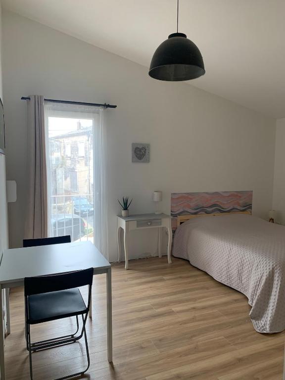 une chambre avec un lit, une table et une fenêtre dans l'établissement Studio indépendant climatisé, à Saint-Drézéry