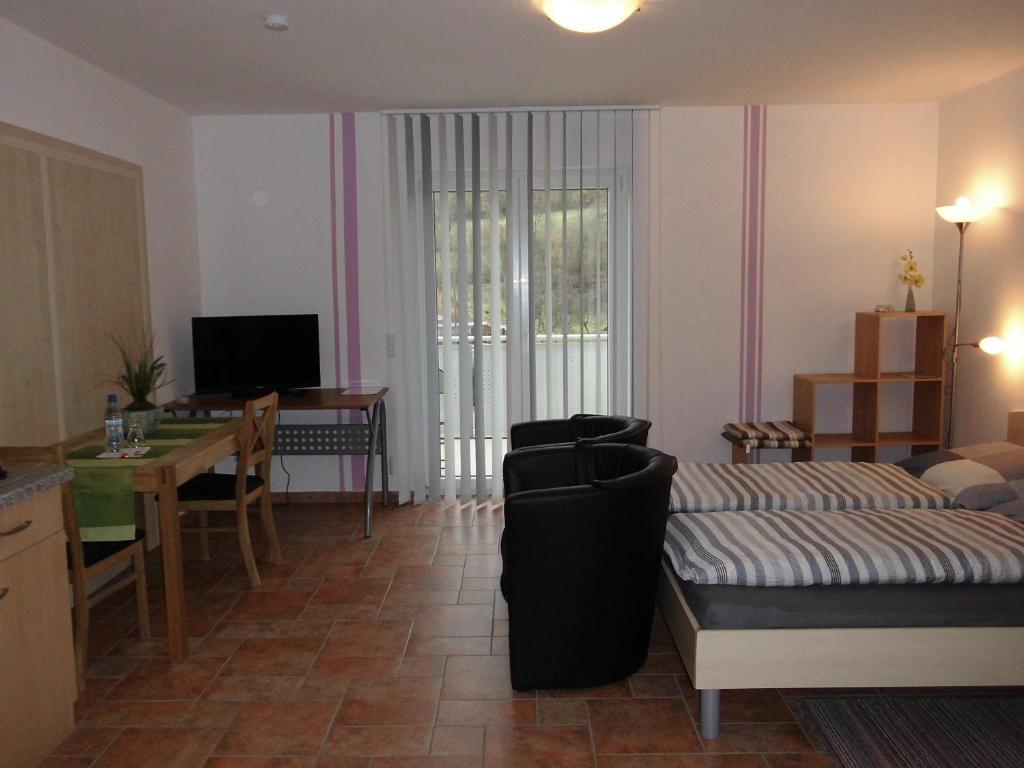 - un salon avec un canapé, une table et un bureau dans l'établissement Ferienhaus Kiesel, à Bad Bocklet