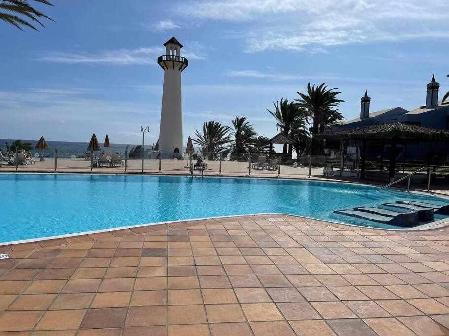 una piscina con un faro en el fondo en Vistas de Ensueño al Mar en Playa del Águila, en Playa del Águila