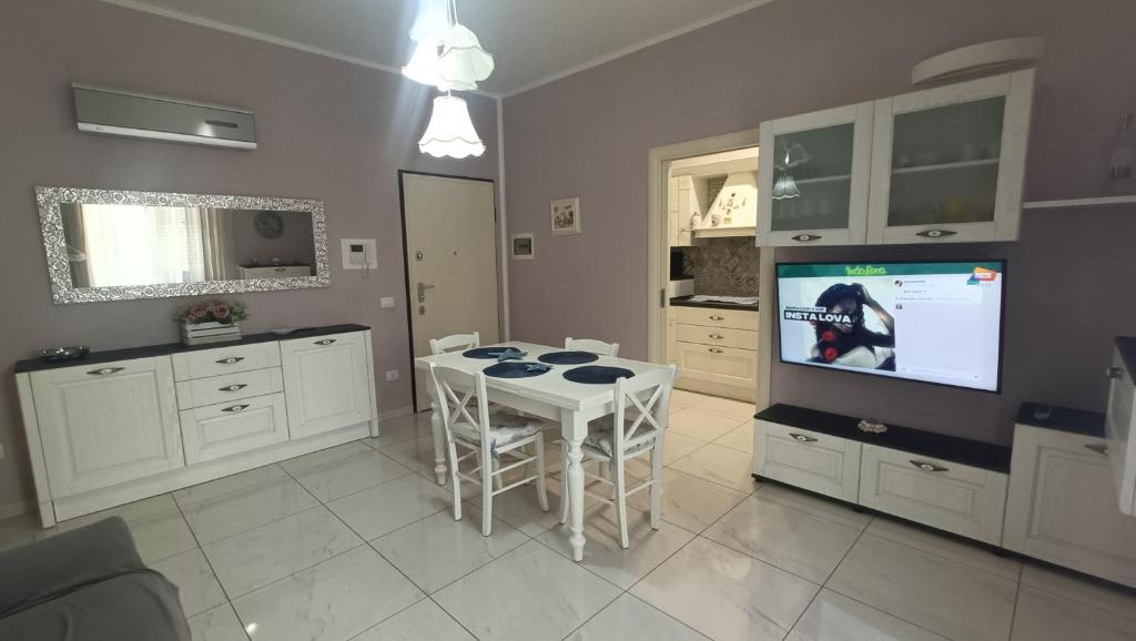 una cocina con mesa y TV. en Beach vibes, en Gallipoli