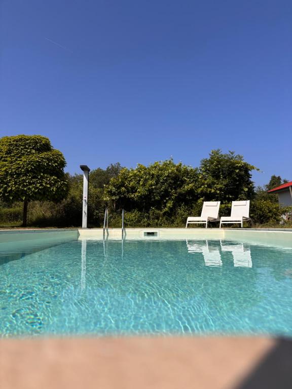 a swimming pool with two white chairs at Casa Anna in Villach