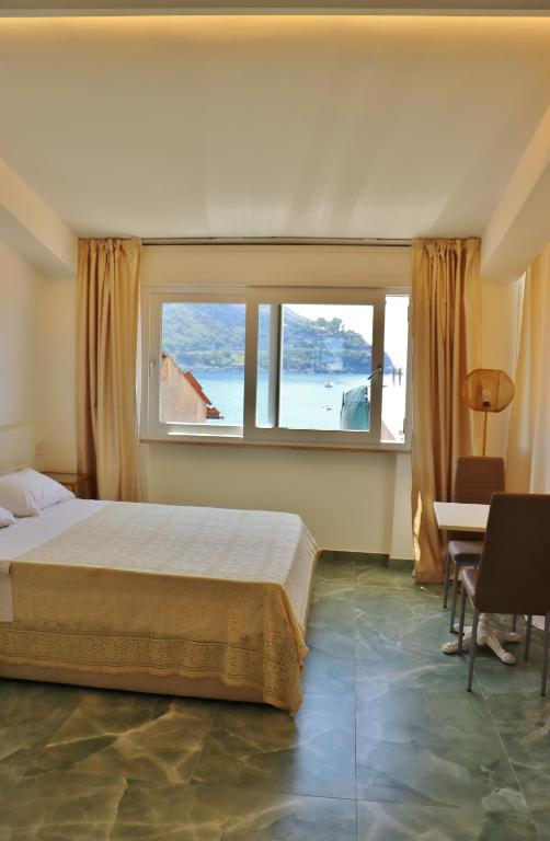 a bedroom with a bed and a large window at Scilla Luxury Rooms in Scilla