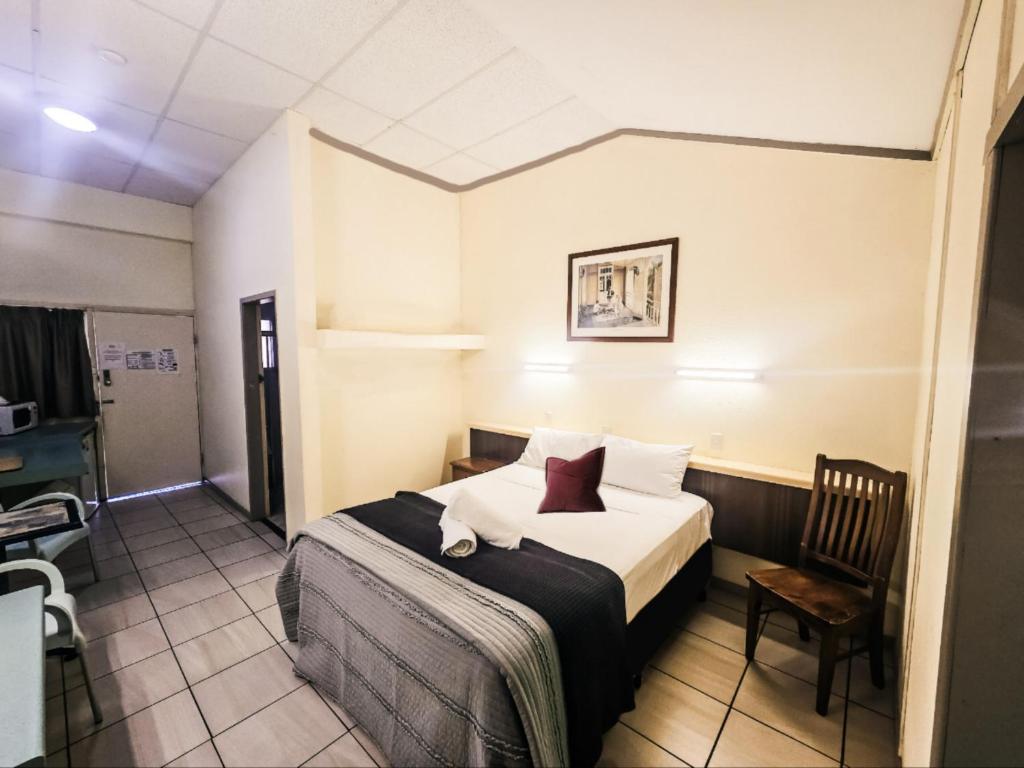 a hotel room with a bed and a chair at Royal Motel Rockhampton in Rockhampton
