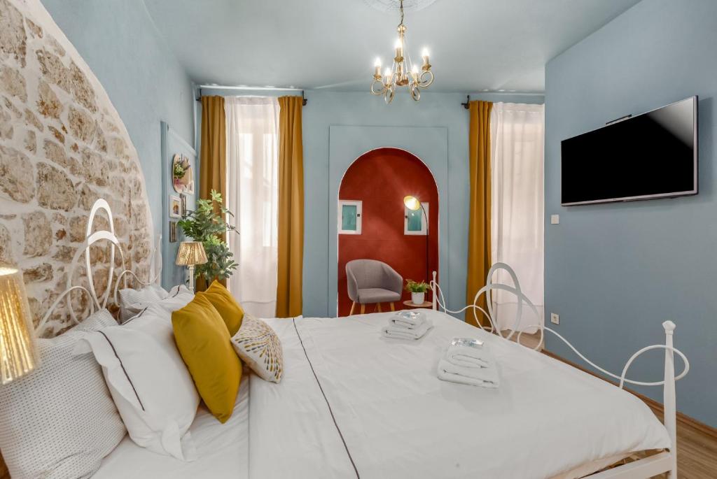a bedroom with a large white bed with yellow pillows at Newly Renovated Romantic Apartment - Primavera Deluxe Rovinj in Rovinj