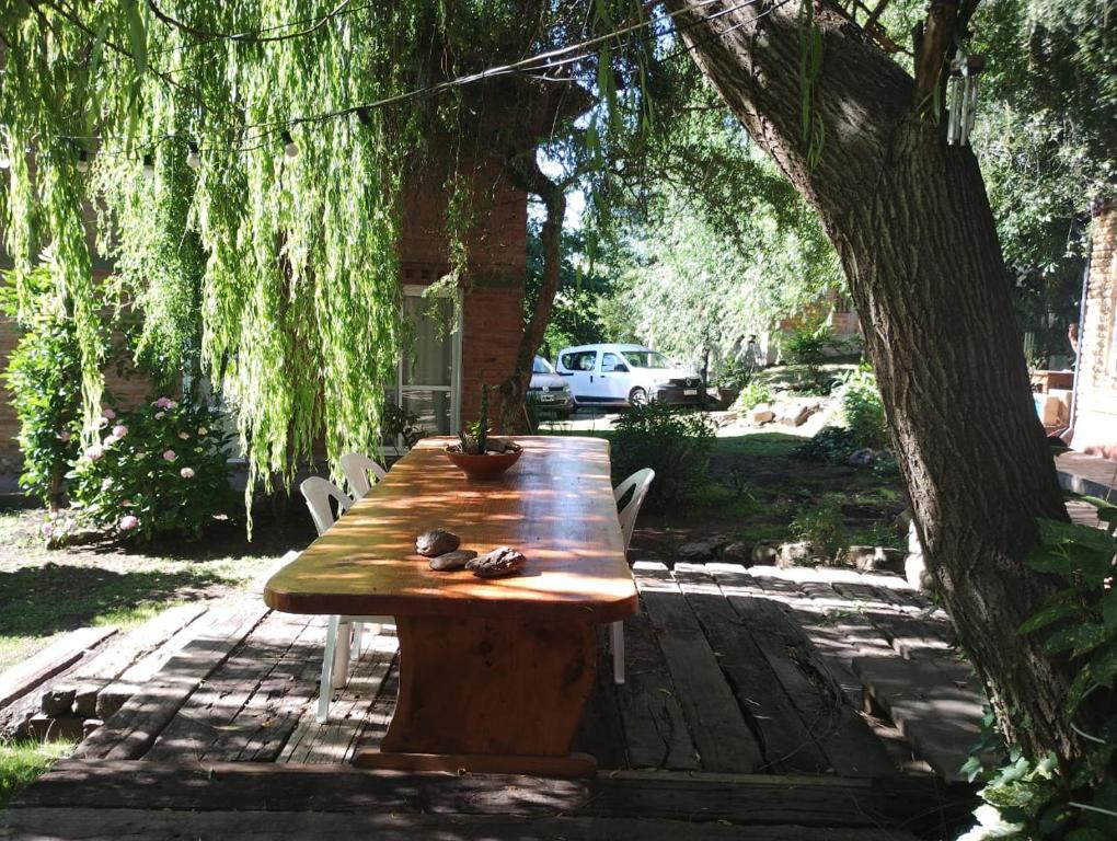 a wooden table sitting under a tree in a yard at Cabañas Ananda in Villa Ventana