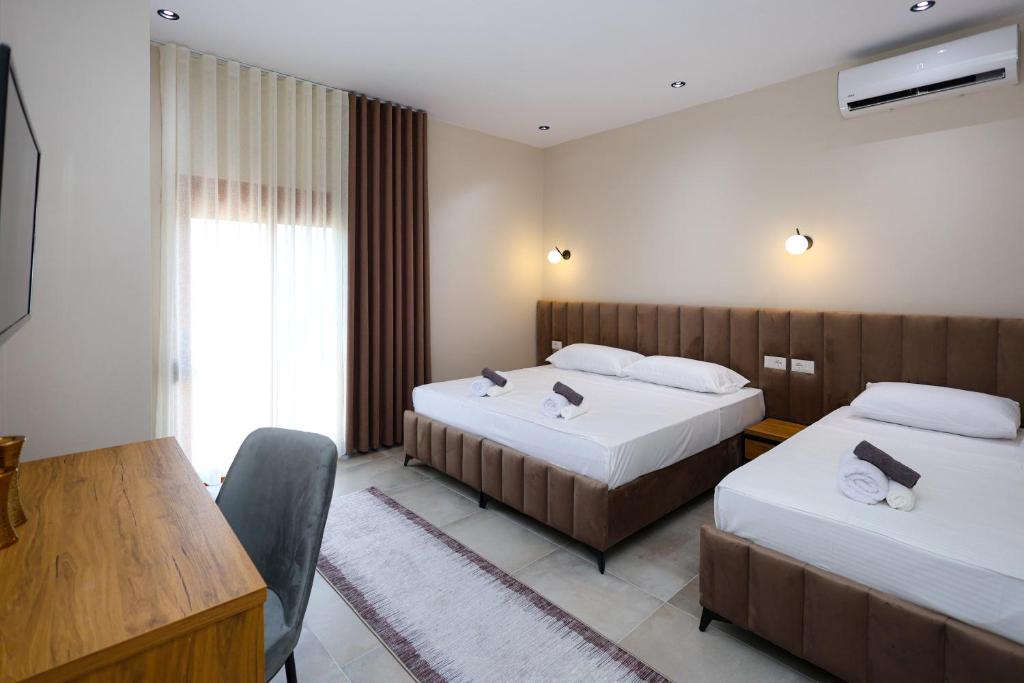 a hotel room with two beds and a table at Vila Erti Berat in Berat