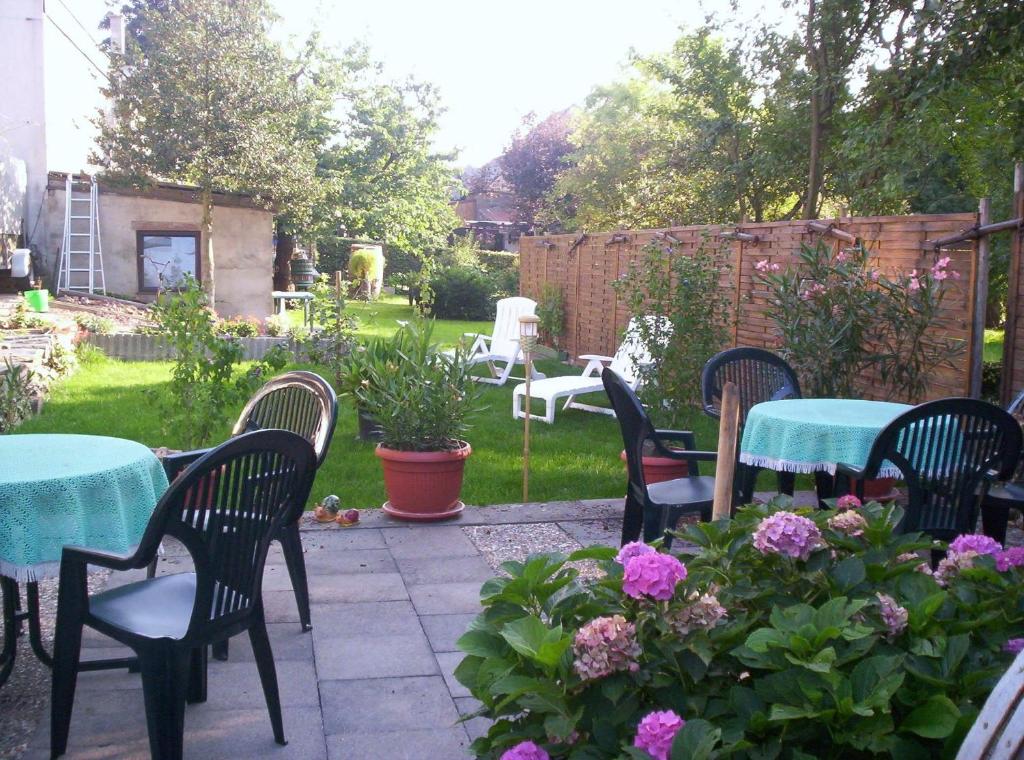 d'une terrasse avec des tables, des chaises et des fleurs. dans l'établissement Hotel - Pension Wendland, à Wintrich