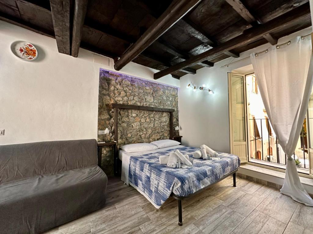 ein Schlafzimmer mit einem Bett und einer Couch in der Unterkunft Osterio Holidays Cefalù in Cefalú