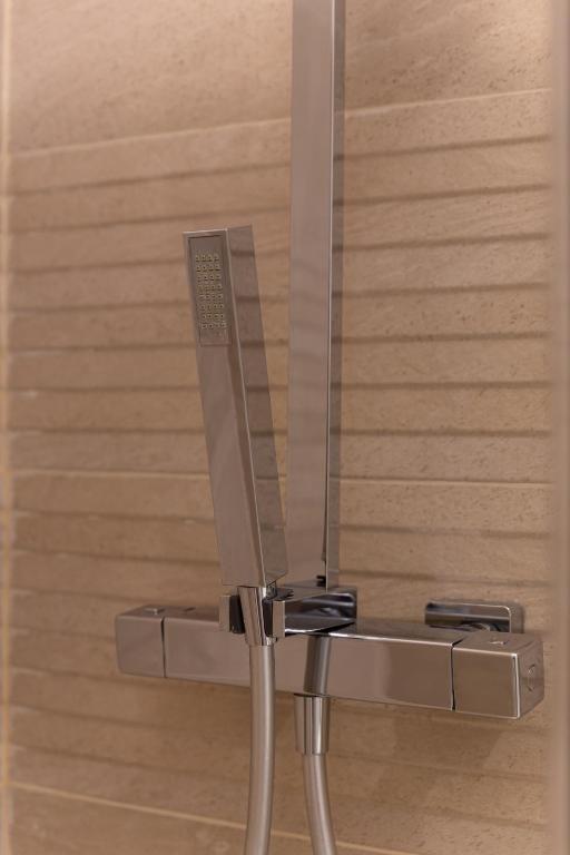 La salle de bains est pourvue d'une douche et d'un miroir. dans l'établissement Le Cocoon Doré, à Clichy