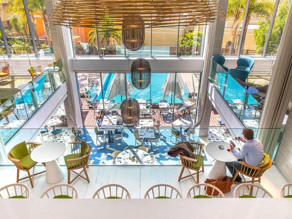 a man sitting at a table on a cruise ship at Novotel Monte-Carlo in Monte Carlo