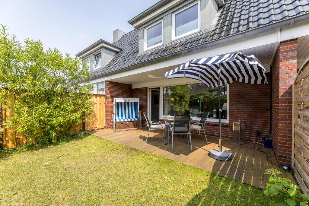 a patio with a table and chairs and an umbrella at Haus Treibholz in Westerland