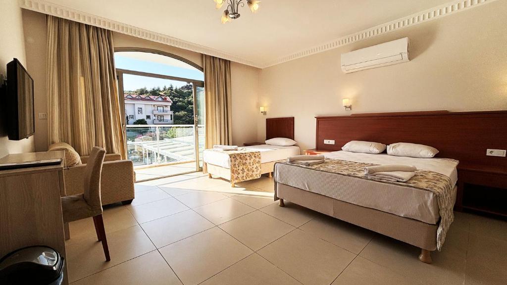 Una habitación de hotel con una cama y una ventana grande. en Forum Residence Hotel, en Marmaris