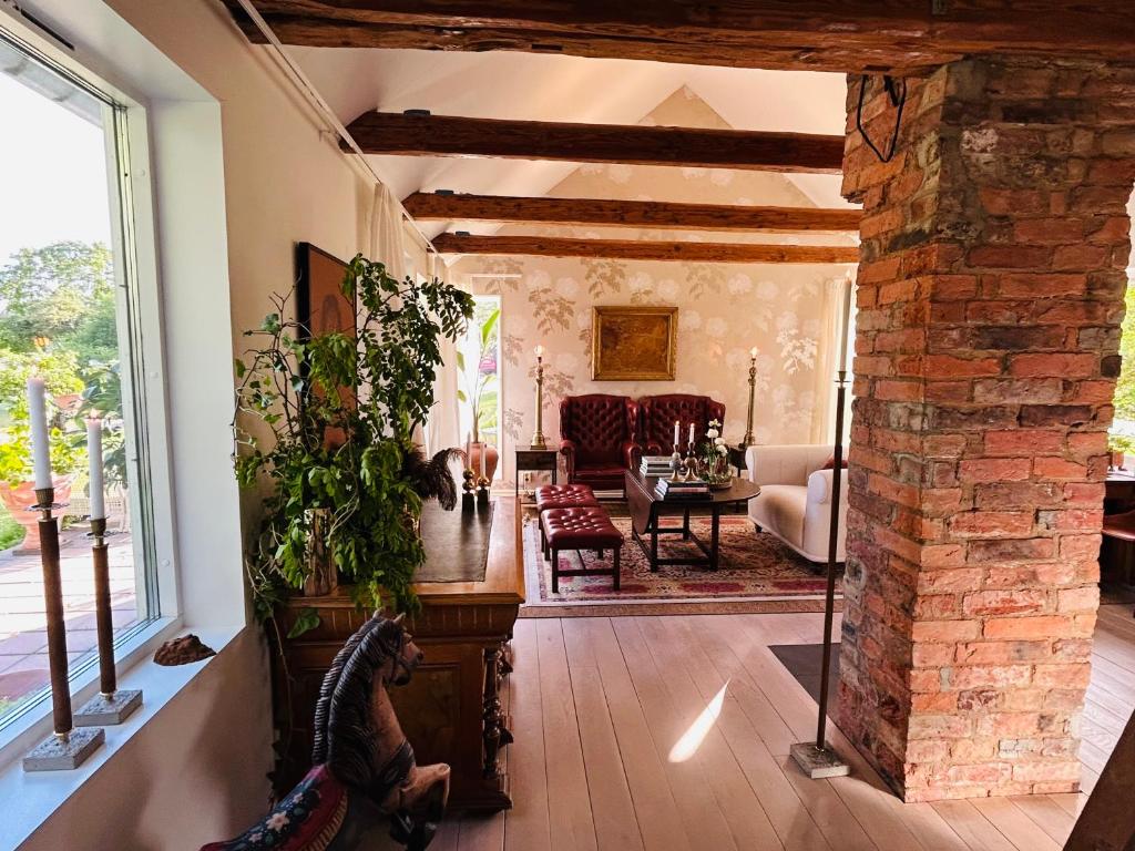 a living room with a large window and a brick fireplace at La Casa del cavaliere in Vassmolösa