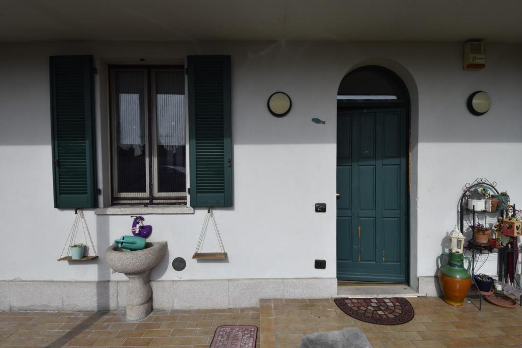 a house with a green door and windows at Casa Carmela in Angera