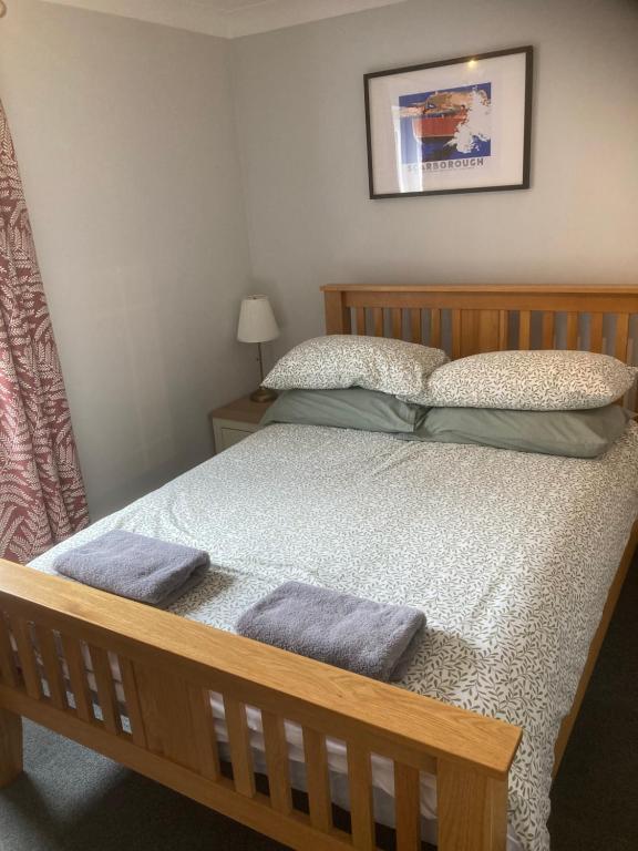 a bedroom with a wooden bed with two pillows at The Old Penny Bank in Barrow upon Humber