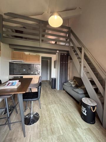 - un salon avec un escalier, une table et des chaises dans l'établissement Les Cottages 1 - Studio au bord de l'océan, à Biscarrosse