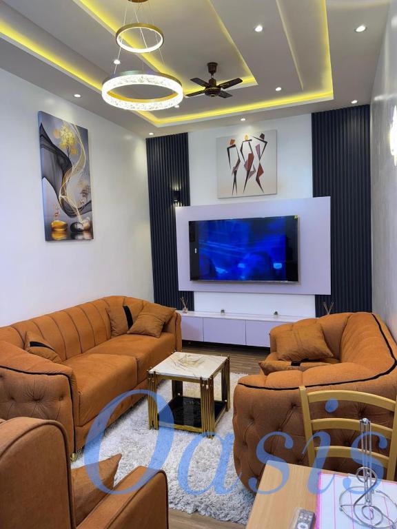 un soggiorno con due divani e una TV a schermo piatto di Oasis a Cotonou
