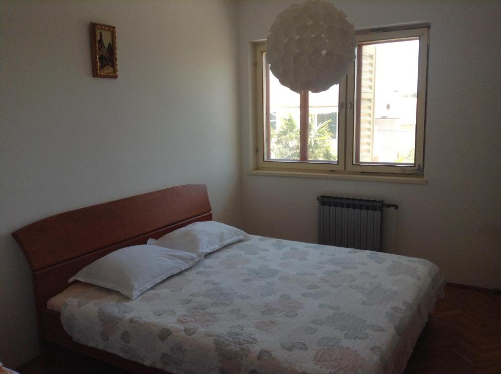 sypialnia z łóżkiem i oknem w obiekcie Apartments Meri w Szybeniku