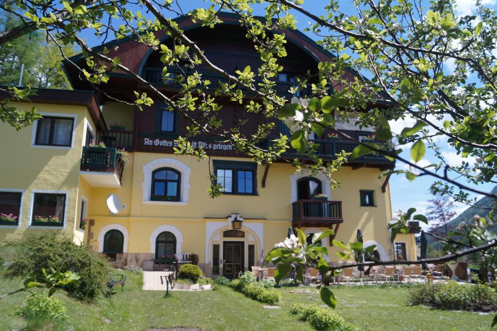 ein großes gelbes Haus mit einem Baum in der Unterkunft Belvedere in Semmering