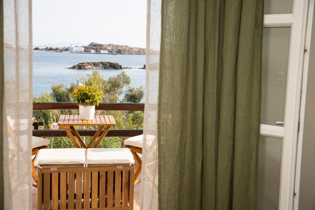 a balcony with a table and a view of the water at Golden Palm Tree Maisonette in Finikas