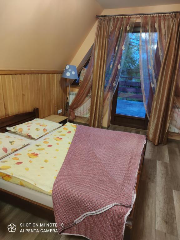 sypialnia z łóżkiem i oknem w obiekcie Maria Chyc wynajem pokoi gościnnych w Zakopanem