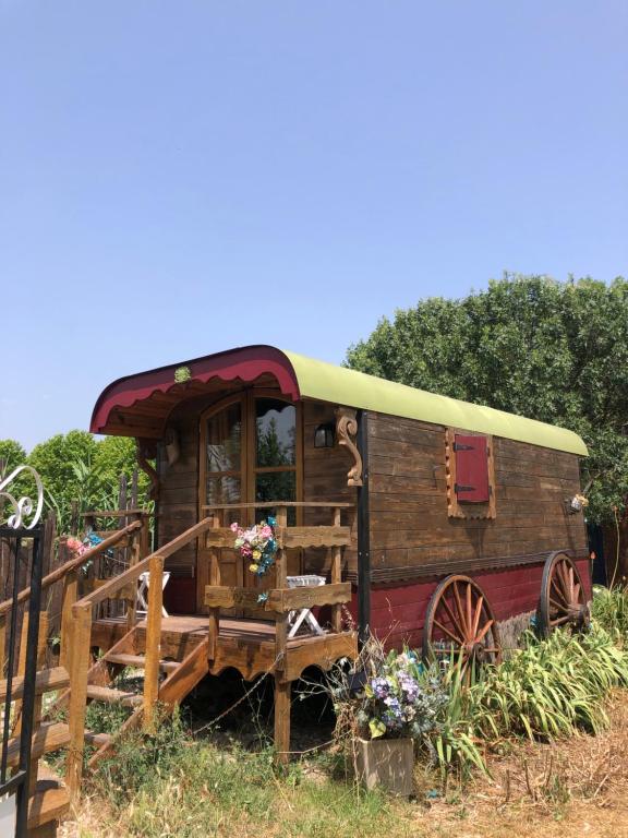 an old train car is sitting in the grass at Roulotte au bord du canal du midi argeliers in Argeliers