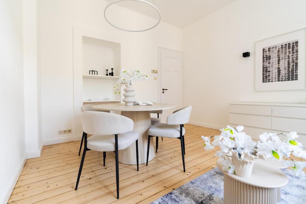 a white dining room with a table and chairs at 2BR Apartment - ZENTRAL - MODERN - WIFI - KAFFEE - BUSINESS - NETFLIX in Wiesbaden