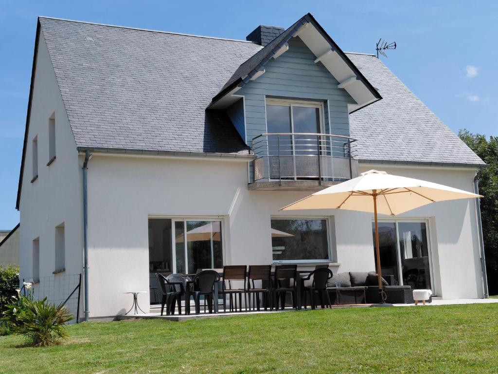 a house with a patio and an umbrella at Maison du Mont César in Montchaton
