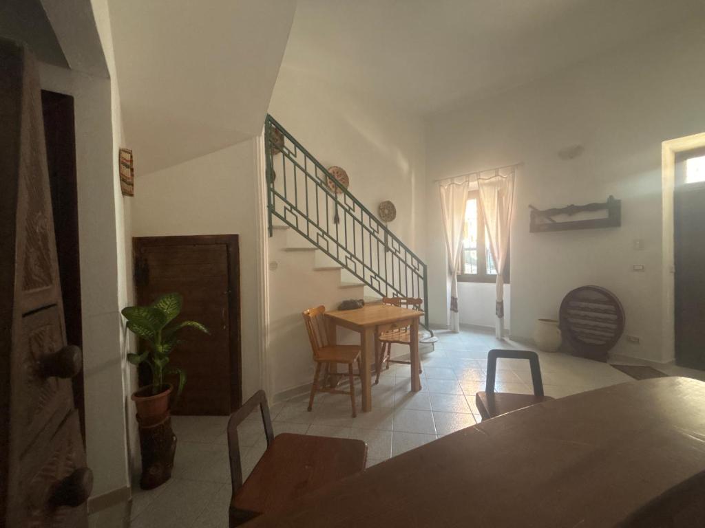 a living room with a table and chairs and a staircase at Domo Via Ozieri in Iglesias
