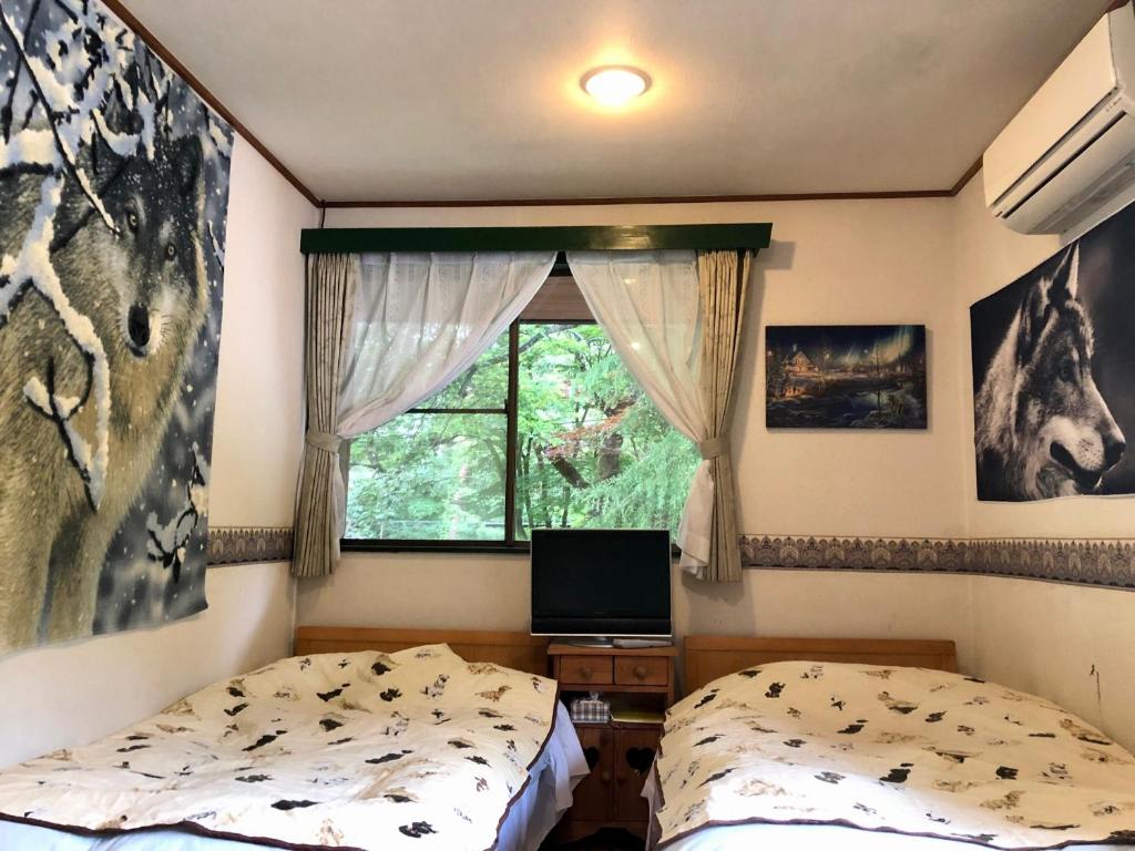 a bedroom with two beds and a window at ドッグランドサムデイ in Minamitsuru