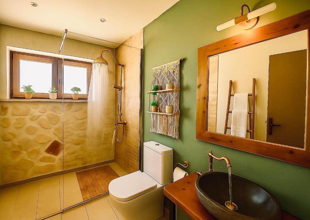 a bathroom with a sink and a toilet and a mirror at La Casa Del Sole in Agios Leon