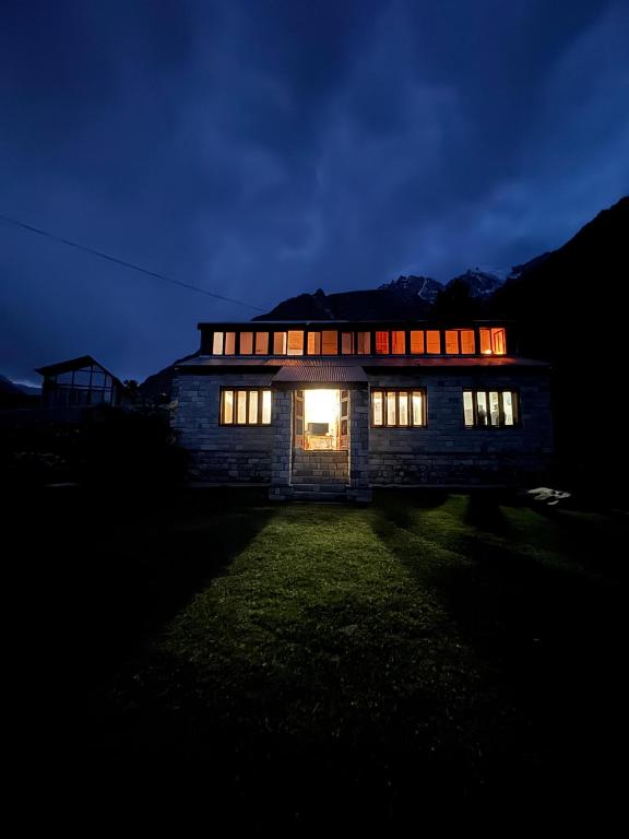 a house lit up at night with its lights on at The Walnut Tree Lodge, Naltar in Jugut